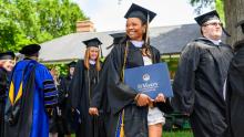 Graduates in cap & gown carrying diplomas